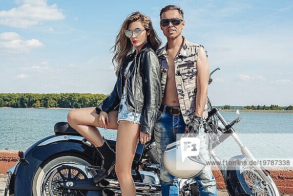 Verliebtes Paar reist auf einem Motorrad in der Nähe des Ozeans. Familie  Tourismus  Liebe Konzept. Gemischte Medien