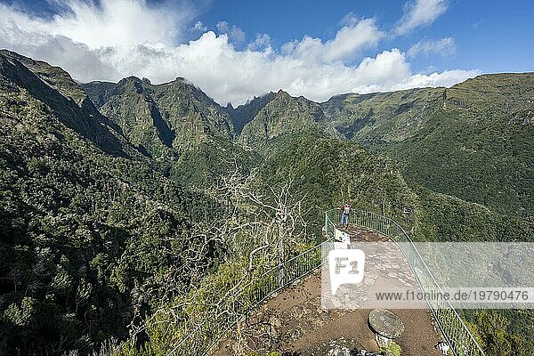 Tourist an einem Aussichtspunkt  Ausblick vom Miradouro dos Balcões  Dicht bewachsene steile Berge  grüne Berglandschaft  Bergtal Ribeira da Metade und das Zentralgebirge  Madeira  Portugal  Europa