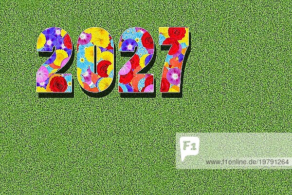 Jahreszahl  Jahr 2027 geschrieben mit bunten Blumen auf grünem Hintergrund  Grafik  Computermontage  Grafikdesign