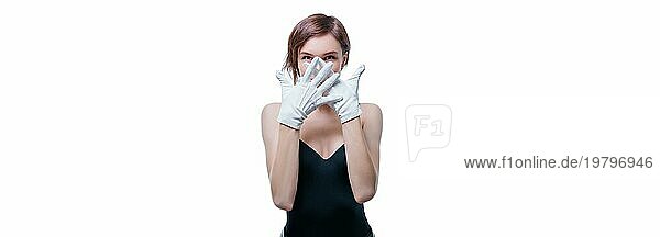 Verwirrtes Mädchen mit weißen Handschuhen posiert im Studio auf weißem Hintergrund. Porträt ohne Namen. Gemischte Medien