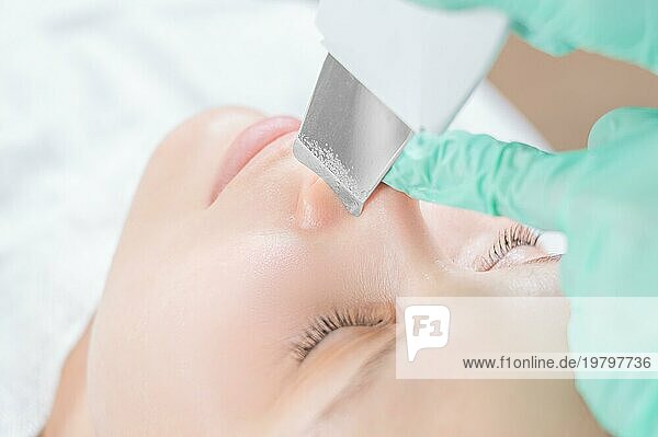 Junge hübsche Frau  die in einem Schönheitssalon behandelt wird. Ultraschall Reinigungsverfahren. Hardware Kosmetologie.