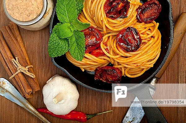 Italienische Spaghetti und Tomaten mit Minzblättern auf Eisenpfanne über Holzbrett  Food photography  Food photography  Food photography