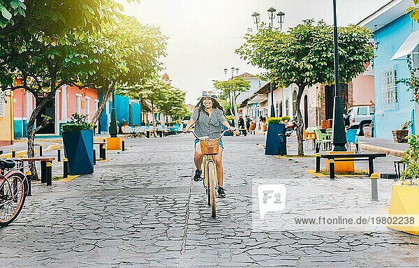 Glückliches Touristenmädchen auf dem Fahrrad in der Calzada Straße. Junge Touristin auf dem Fahrrad in den Straßen von Granada  Nicaragua  Mittelamerika