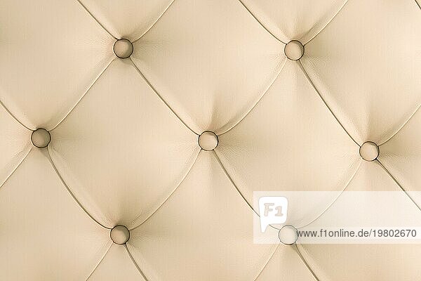 Beige weichen Wandteppich Muster Hintergrund mit symmetrischen Tasten an den Ecken der Diamanten. Weiche und teure Möbelelemente. Luxus Hintergrund