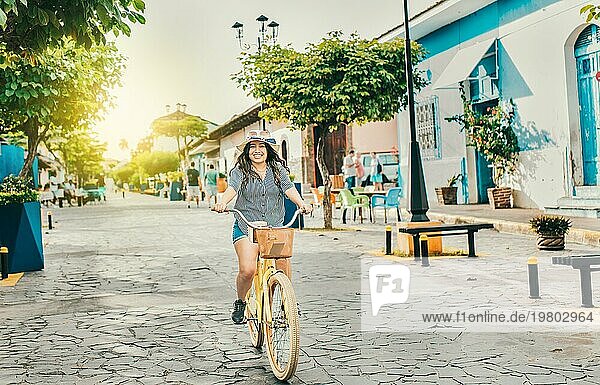 Lächelnde Touristin auf einem Fahrrad in den Straßen von Granada. Schönes Mädchen auf einem Fahrrad auf der Straße von La Calzada  Granada  Nicaragua  Mittelamerika