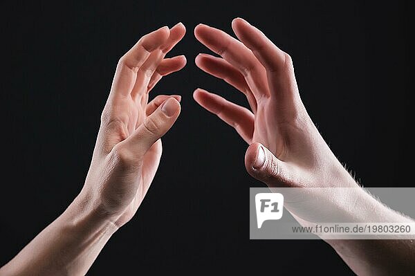 Eine Nahaufnahme von zwei Händen  Männchen und weiblich  die sich sanft berühren. Das Konzept der zittrigen Ablehnung zwischen den Geschlechtern. Warme Beziehungen zwischen Männern und Frauen