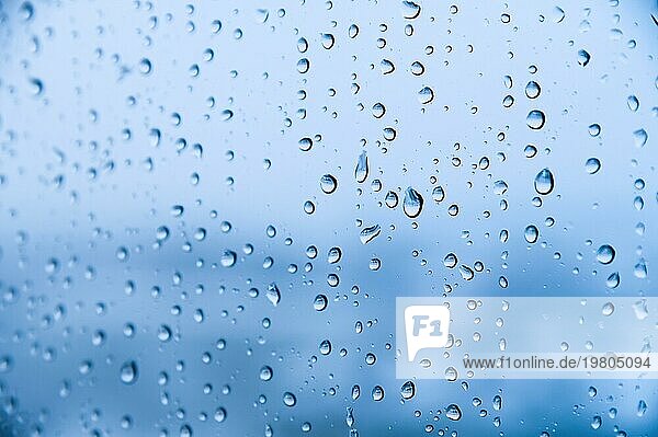 Regentropfen auf blauem Glas Hintergrund. Herbst abstrakten Hintergrund