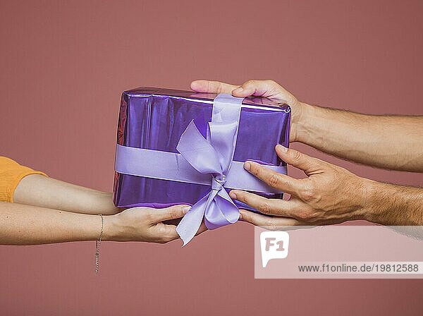 Close up Hände halten lila verpackt Geschenkbox