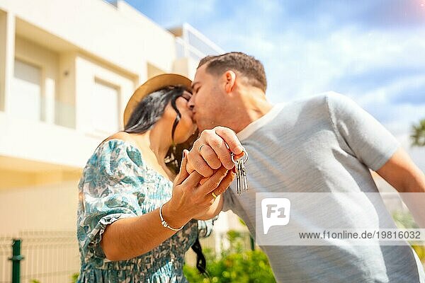 Glückliches Paar  das sich küsst  um zu feiern  dass es ein Haus gekauft hat