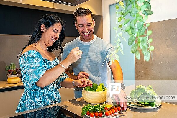 Ein frisch verheiratetes Paar bereitet zu Hause in einer neuen Küche gesundes Essen zu