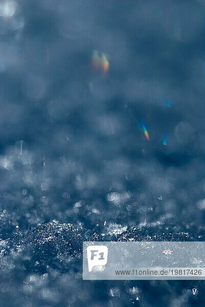 Glänzende Schneekristalle  Schneeflocken in einer Makroaufnahme mit minimaler Schärfentiefe  in einigen Schneekristallen bricht sich das Licht zu Regenbogenfarben  Lichtbrechung  Physik  Schneedecke an einem sonnigen Wintertag  Bokeh  stimmungsvolles Licht mit subtilen Glanzpunkten  Niedersachsen  Deutschland  Europa