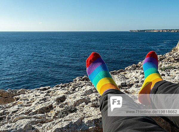 Socken mit den Farben der Flagge der LGBTQ Gemeinschaft. Entspannt vor dem Meer. Stolz Konzept mit Kopie Raum