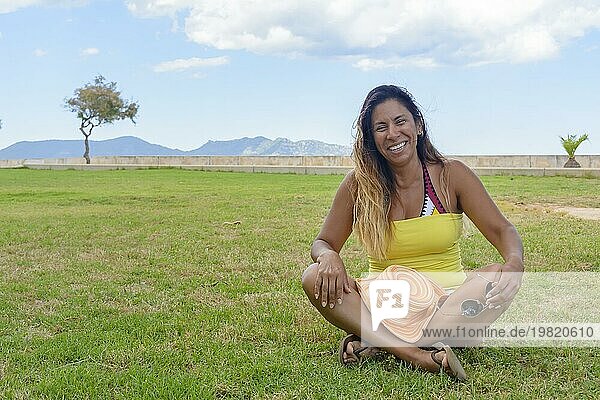 Porträt einer lateinischen Frau lächelnd  Spaß haben  im Urlaub in mallorca posiert auf einem warmen Frühling Sommer Tag  unter einer Palme  Urlaub