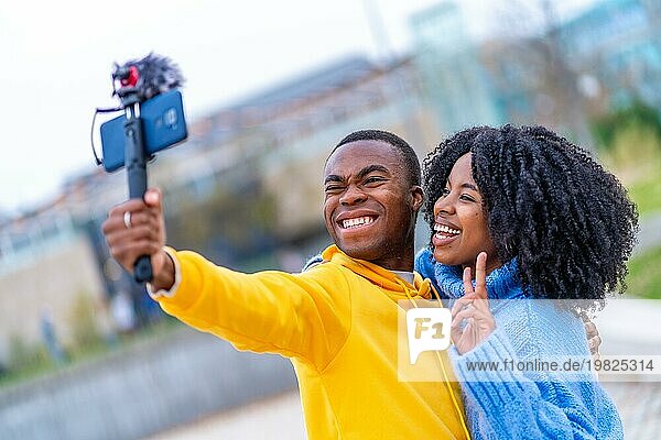 Afrikanische Jugendliche lächeln und gestikulieren den Sieg  während sie ein Video auf der Straße aufnehmen