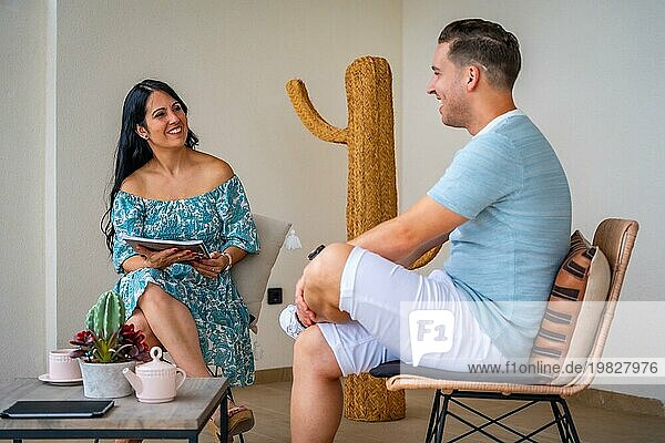 Frisch verheiratetes romantisches Paar trinkt Kaffee und unterhält sich auf der Terrasse zu Hause
