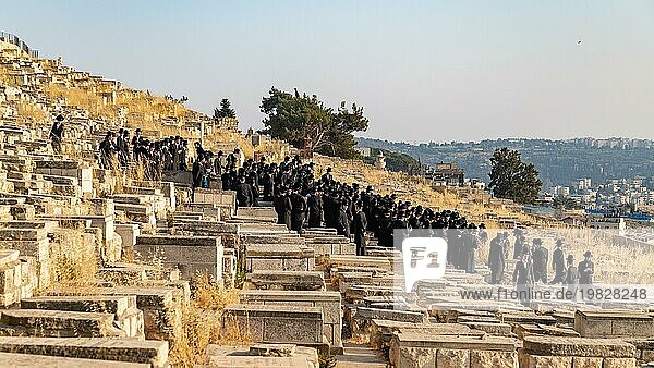 Ein Bild von Männern  die an einer jüdischen Beerdigung teilnehmen