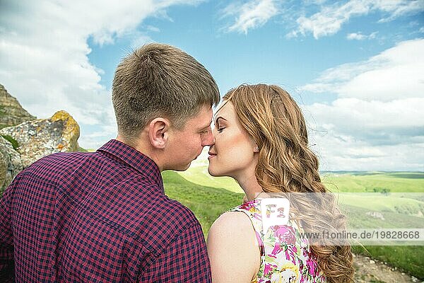 Ein junges Ehepaar reicht sich vor dem Hintergrund einer wunderschönen Natur die Hand zum Kuss. Konzept einer glücklichen jungen Familie
