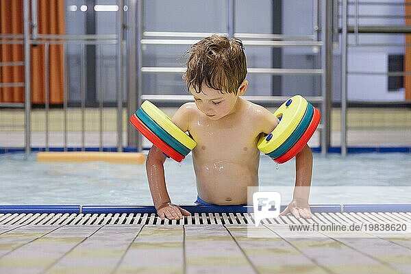 Topic: Child with water wings at the edge of the pool