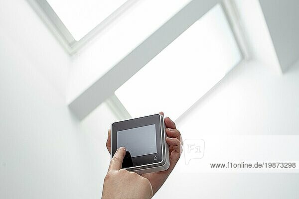 Handbedienung einer Fernbedienung eines Dachfensters im Innenbereich. Hausautomation. Raum kopieren