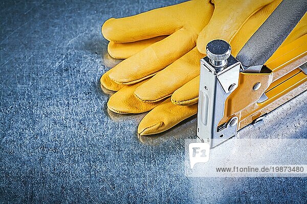 Gelbe Lederschutzhandschuhe Bauhefter auf metallischem Hintergrund