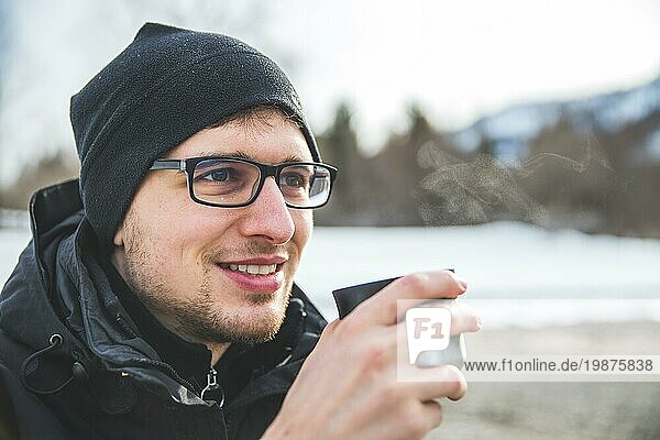 Kaukasischer Mann hält eine Tasse Tee im Freien  Winterzeit