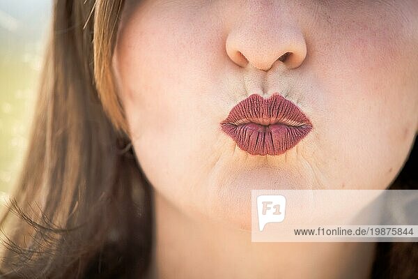 Kirschrote Lippen eines jungen Mädchens küssen sich