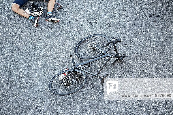 Unfall mit einem Fahrrad auf der Straße Szene eines Radfahrers und seines Fahrrads auf dem Asphalt  nachdem er von einem Fahrzeug angefahren wurde