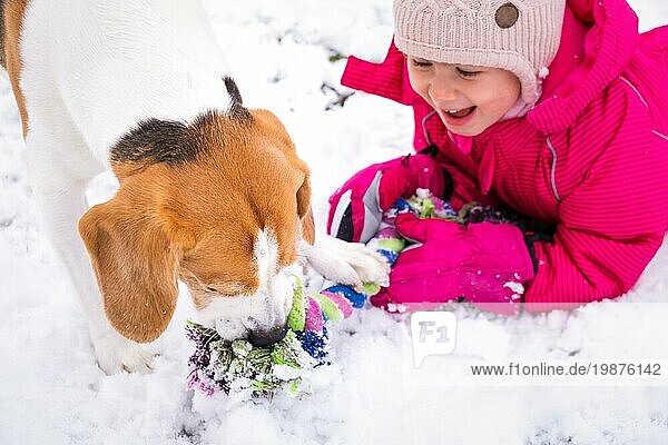 Kind spielt mit Hund im Schnee. Hund mit Kindern Konzept