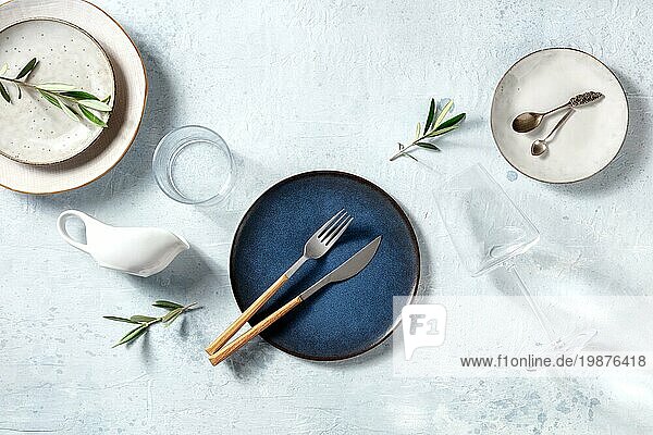 Modernes Keramikgeschirr  Overhead Flachbildaufnahme mit Olivenzweigen. Mediterrane Küche Restaurant Konzept. Trendige Teller und Gläser  Ansicht von oben