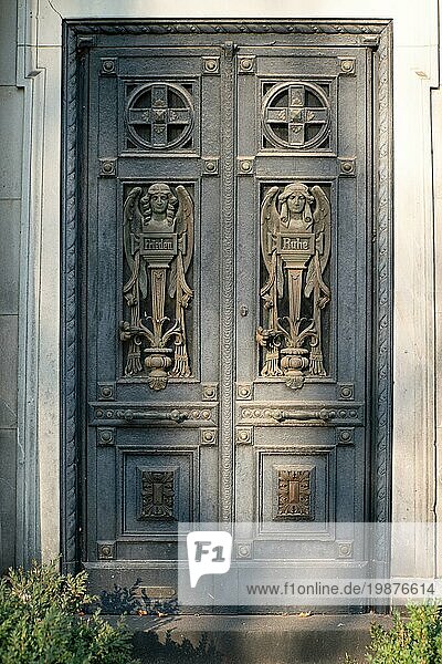 Alte Tür mit zwei Engeln und den Worten Frieden und Ruhe sowie ornamentalen Schnitzereien