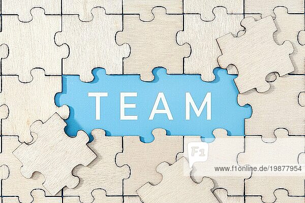 Team Wort auf blauem Hintergrund  umgeben von Puzzleteilen
