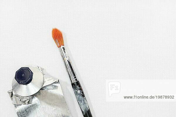 Künstler Pinsel und Squeeze Ölfarbe Rohr auf weißer Leinwand Hintergrund. Leerzeichen kopieren
