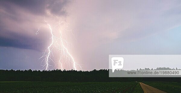 Nächtlicher Blitzschlag über ländlichem Gebiet. Landwirtschaftliche Felder