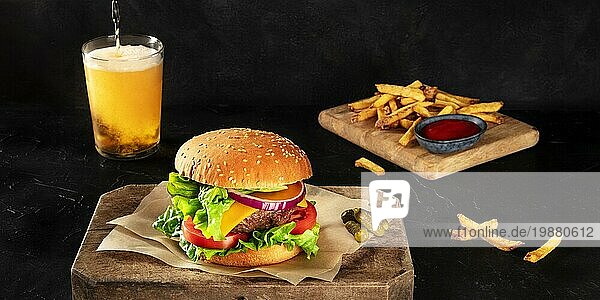 Burger und Bierausschank Panorama. Hamburger mit Rindfleisch  Käse  Zwiebel  Tomate und grünem Salat  auf dunklem Hintergrund mit Platz für Text. Selektiver Fokus