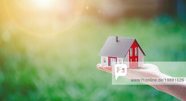 Neues Haus und Hauskonzept: Rotes Haus Modell im Freien in männlicher Hand  Kopie Raum