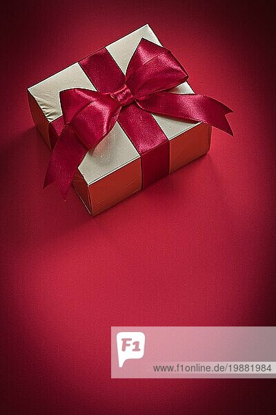 Geschenkbox mit Schleife auf rotem Hintergrund Urlaub Konzept