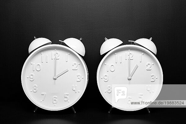 Daylight saving time Konzept. Zwei weiße Retrouhr vorschwarzem Hintergrund. Kopieren Raum