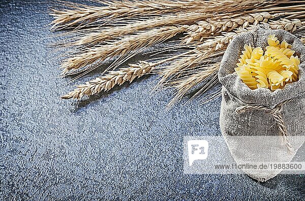 Sackleinen Sack mit Makkaroni Weizen Roggen Ohren auf schwarzem Hintergrund