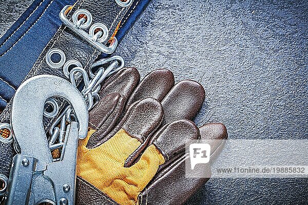 Construction Gurtzeug Sicherheit Lederhandschuhe auf schwarzem Hintergrund Wartung Konzept