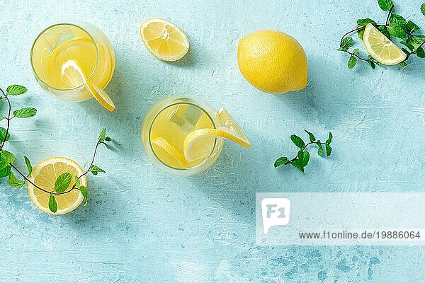 Limonade auf einem blaün Hintergrund mit Platz für Text. Hausgemachtes frisches Getränk mit Zitrone und Minze  mit Eis  Overhead Flachbildaufnahme mit Platz für Text. Gesunde natürliche Sommerdiät