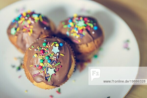 Hausgemachte süße Cupcakes auf einem Teller mit bunter Dekoration