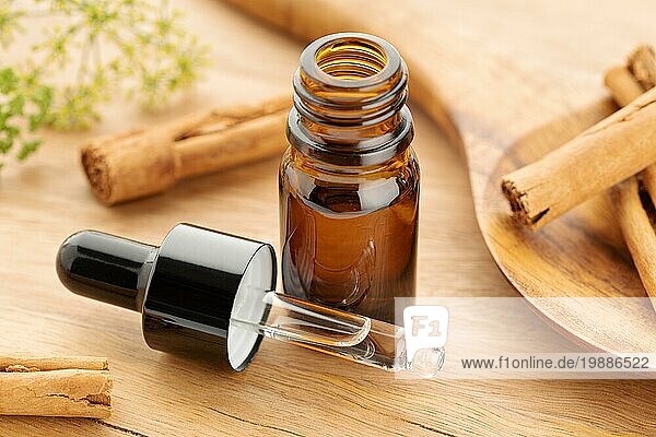 Ätherisches Zimtöl in einer Flasche auf einem Holztisch. Alternative Medizin