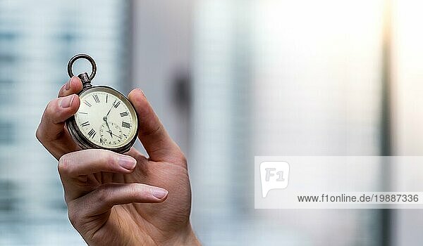 Die Zeit vergeht: Mann hält eine alte Uhr in der Hand  geschäftlicher Kontext  Kopierraum