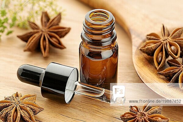 Ätherisches Öl aus Sternanis in einer Flasche auf einem Holztisch. Alternative Medizin