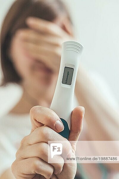 Nervöse Mutter hält Schwangerschaftstest in den Händen  Ergebnis ist schwanger  ?Schwanger?