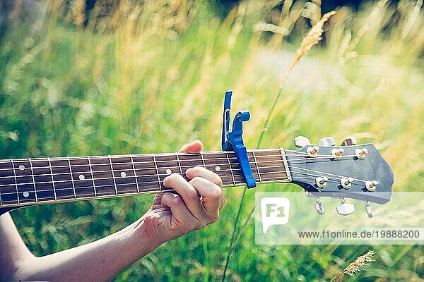 Nahaufnahme einer Westerngitarre  die im Freien an einem Fluss gespielt wird  Sommerzeit