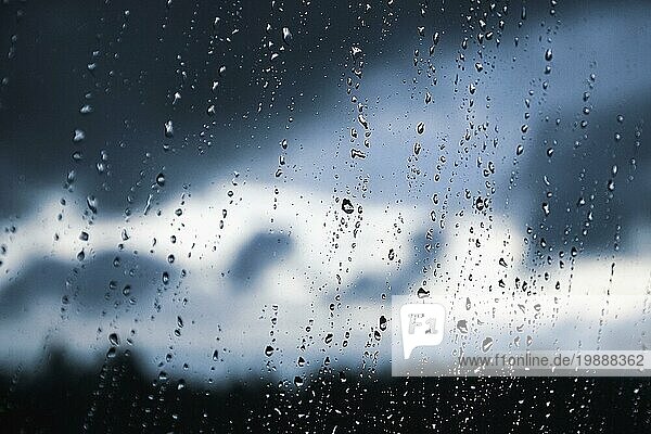 Regentropfen auf der Fensterscheibe. Schwarz  grau  weiß Gradient auf verschwommenen Hintergrund. Bewölktes regnerisches Wetter vor dem Fenster. Kühlung  Regen  schlechte Wettervorhersage