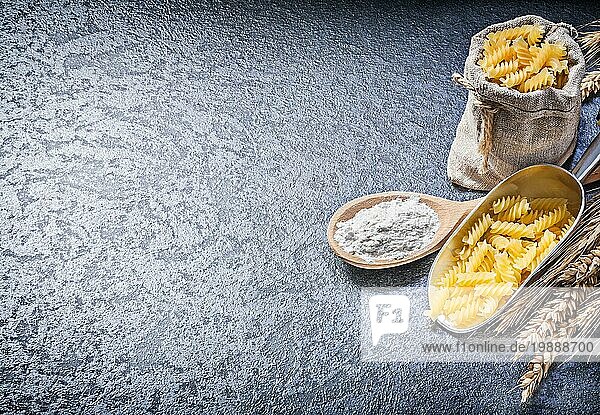 Sack Sack ungekochte Makkaroni Küche Schaufel Holzlöffel Mehl Weizen Roggen Ohren auf schwarzem Hintergrund Kopie Raum