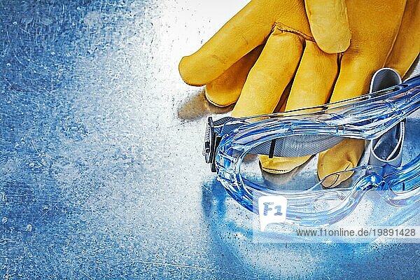 Horizontale Version der Schutzbrille Handschuhe auf metallischem Hintergrund