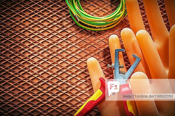 Abisolierzange Elektrokabel Elektrikerhandschuhe auf dielektrischer Matte